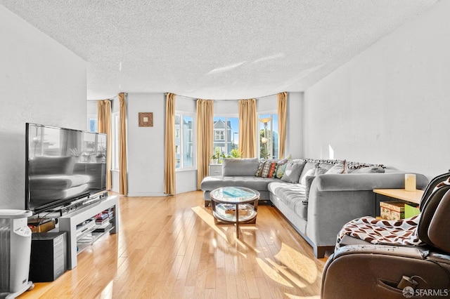 living area with light wood-style flooring and a textured ceiling