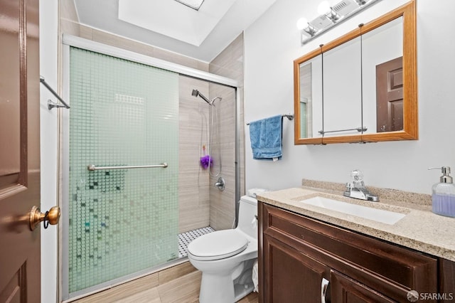 full bath featuring toilet, vanity, and a shower stall