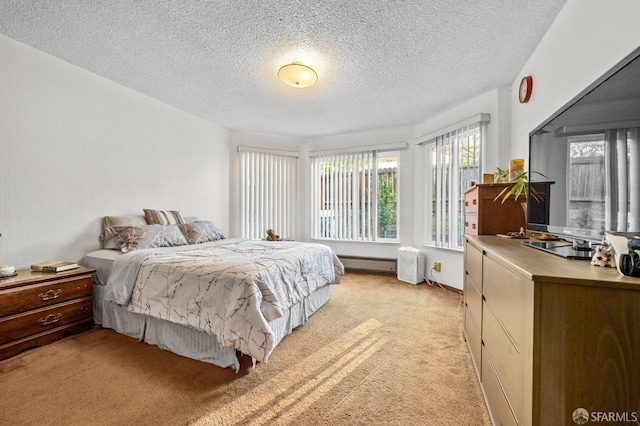 bedroom featuring a baseboard radiator, light colored carpet, and a textured ceiling