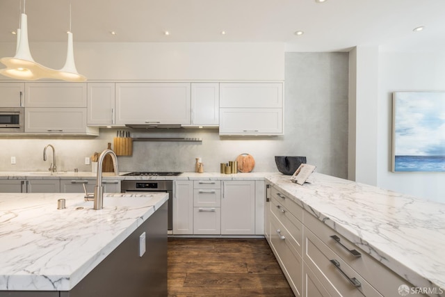 kitchen with stainless steel appliances, dark wood-type flooring, hanging light fixtures, light stone countertops, and tasteful backsplash