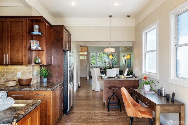 kitchen featuring pendant lighting, dark wood finished floors, open shelves, stainless steel refrigerator with ice dispenser, and backsplash