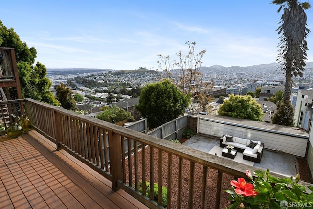 wooden terrace with a fenced backyard, an outdoor hangout area, a patio, and a mountain view