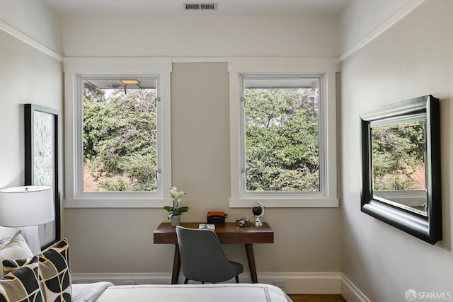 office featuring baseboards, visible vents, and plenty of natural light