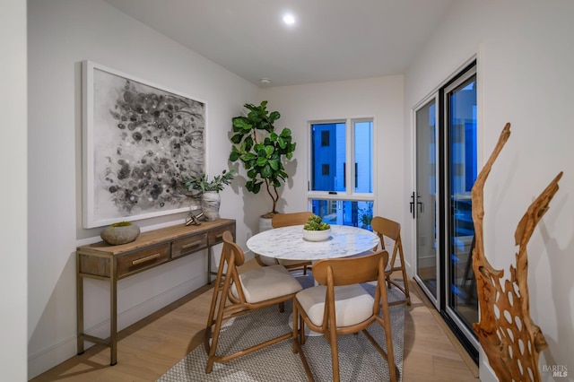 dining area with light wood finished floors and baseboards
