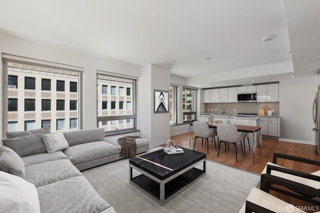 living room featuring recessed lighting, wood finished floors, and baseboards