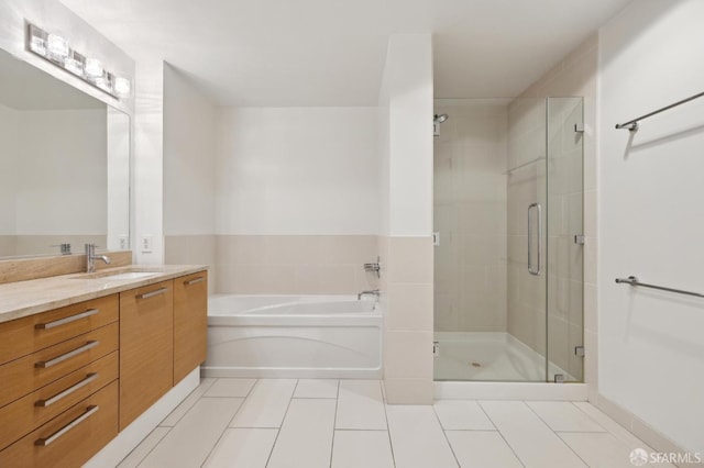 bathroom with a bath, tile patterned flooring, a stall shower, and vanity