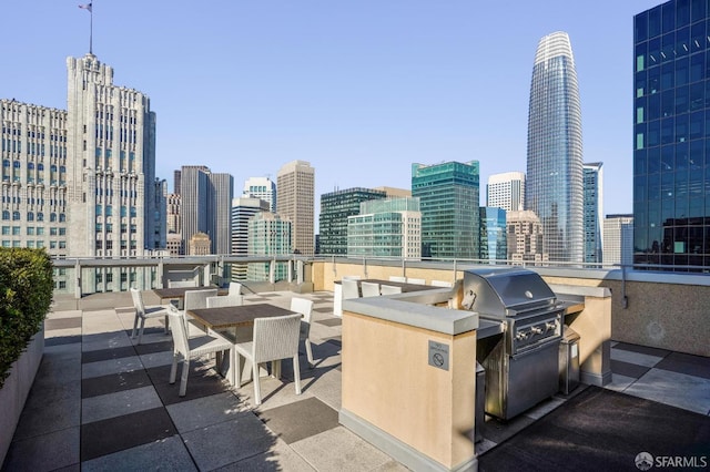 view of patio featuring a city view, exterior kitchen, and grilling area