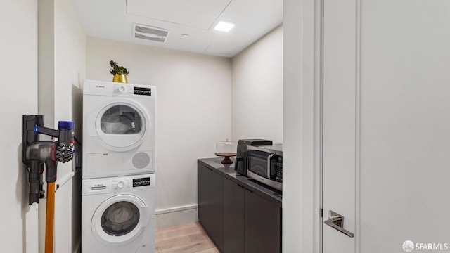 laundry area with stacked washing maching and dryer