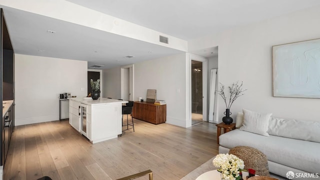 living room with wine cooler and light hardwood / wood-style floors