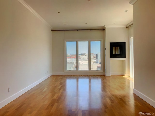 unfurnished room featuring ornamental molding and light hardwood / wood-style floors