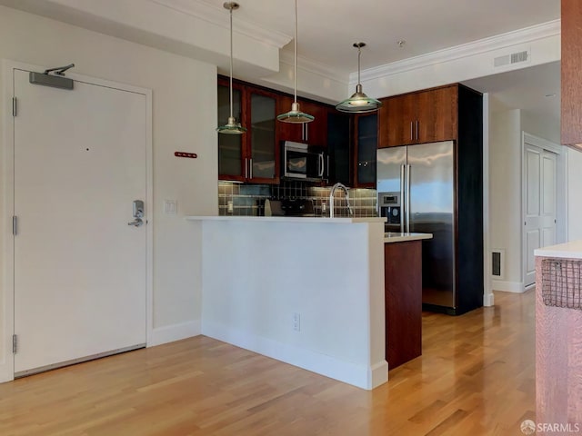 kitchen with decorative light fixtures, stainless steel appliances, tasteful backsplash, kitchen peninsula, and light wood-type flooring