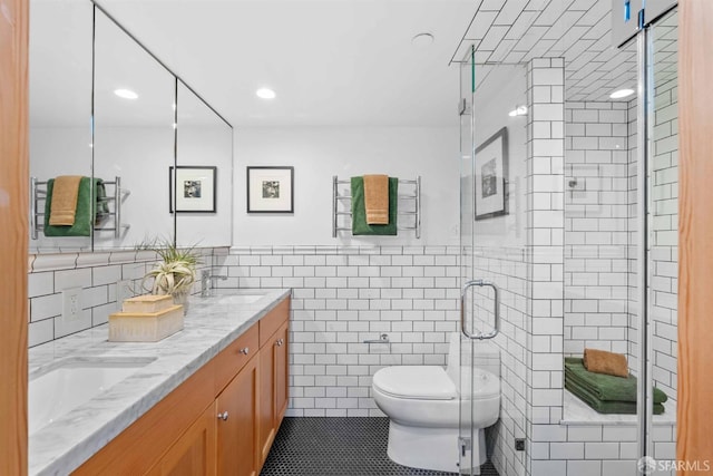 bathroom featuring tile patterned flooring, an enclosed shower, tile walls, toilet, and vanity