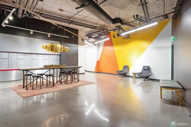 interior space with track lighting, finished concrete flooring, and a high ceiling