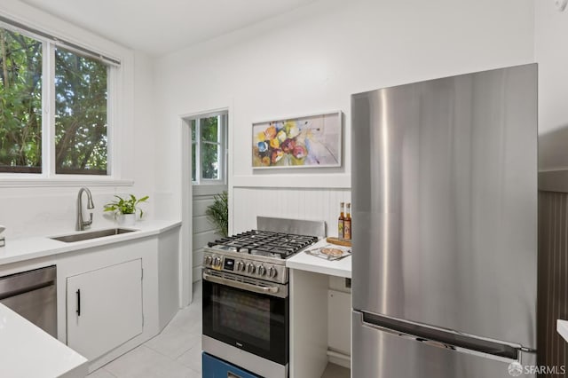 1250 Vallejo St Unit 8, San Francisco, CA 94109 - kitchen with appliances with stainless steel finishes, light countertops, light tile patterned floors, and white cabinetry