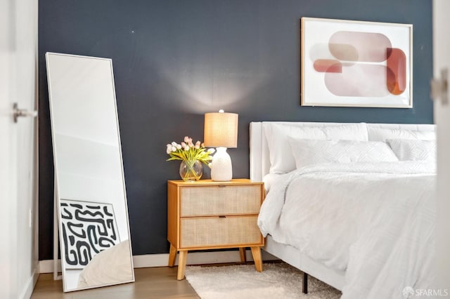 bedroom with baseboards and wood finished floors