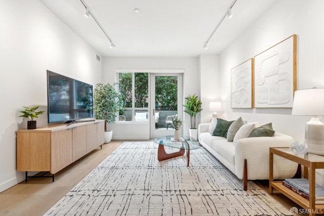 living area with visible vents, light wood-style flooring, and track lighting