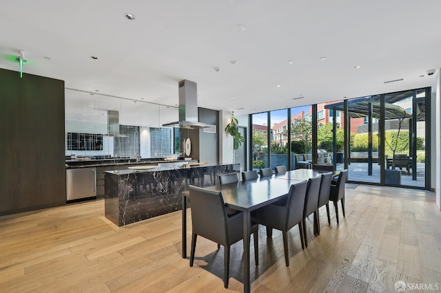 dining area featuring light wood finished floors and floor to ceiling windows