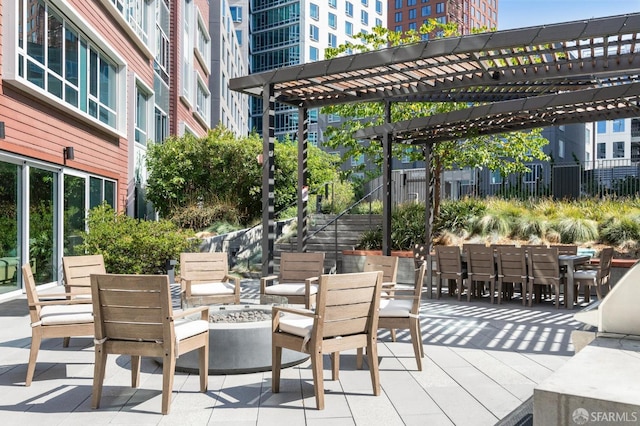 view of patio featuring an outdoor fire pit, outdoor dining space, and a pergola