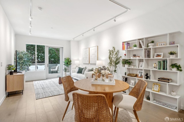 interior space with light wood finished floors and rail lighting