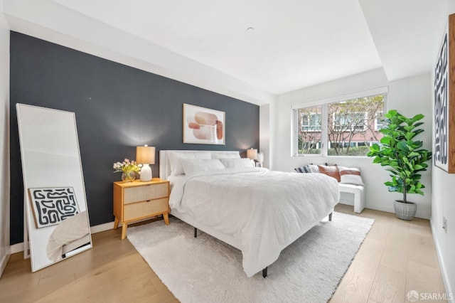 bedroom with light wood-style flooring and baseboards