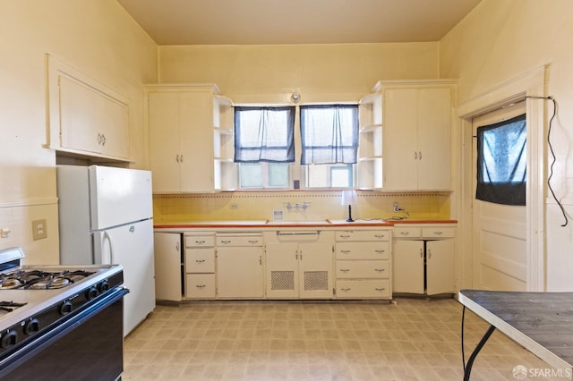 kitchen with tasteful backsplash, gas range, and a healthy amount of sunlight