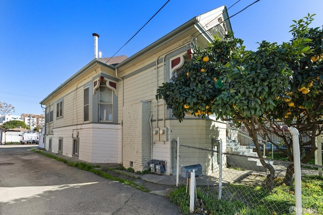 view of home's exterior featuring brick siding and fence