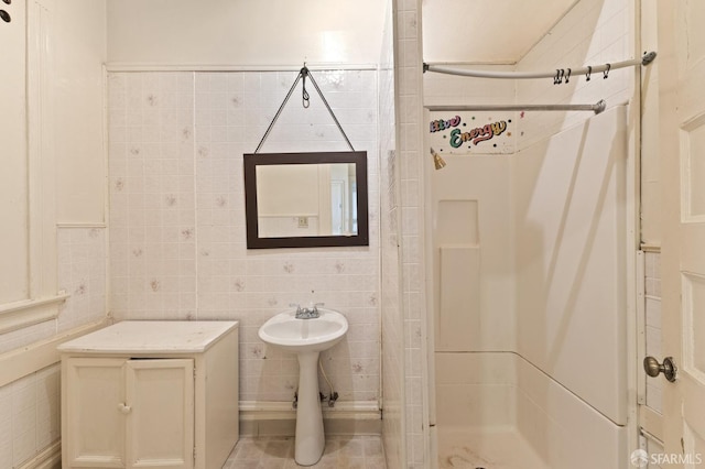 full bath featuring a stall shower and tile walls