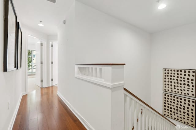 corridor featuring an upstairs landing, recessed lighting, baseboards, and wood finished floors