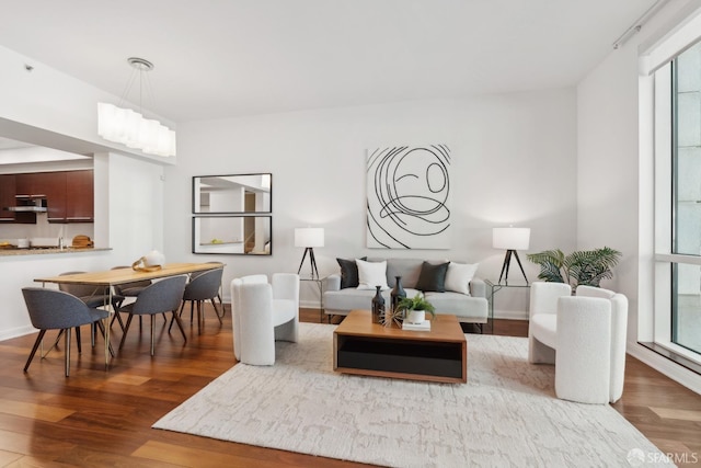 living area with baseboards and wood finished floors