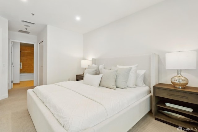 bedroom featuring visible vents, baseboards, light carpet, recessed lighting, and ensuite bathroom