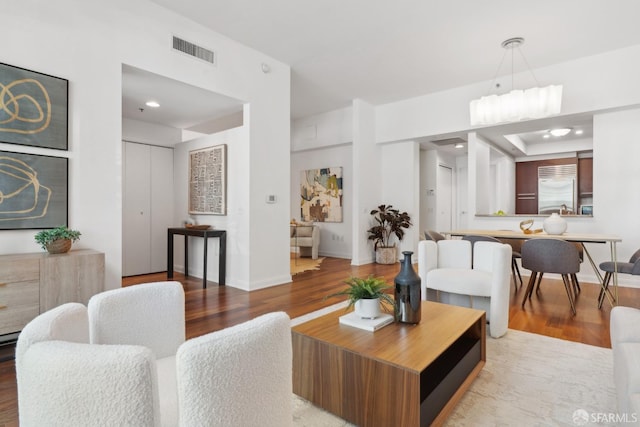 living area featuring recessed lighting, wood finished floors, visible vents, and baseboards