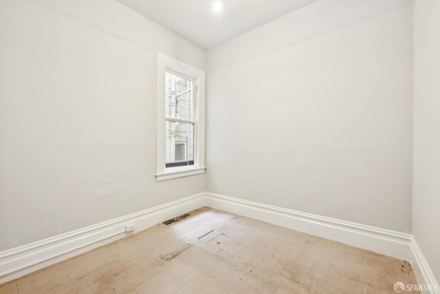 spare room with baseboards