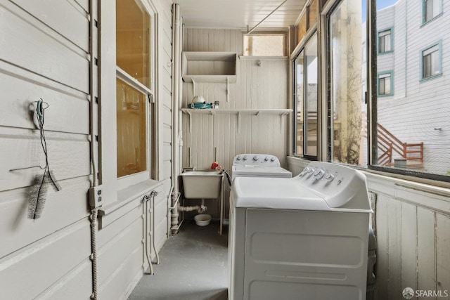 laundry area featuring washing machine and dryer and wooden walls