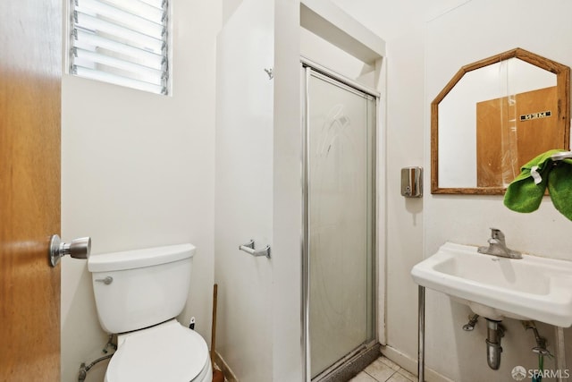 bathroom with a shower stall, toilet, tile patterned floors, and a sink