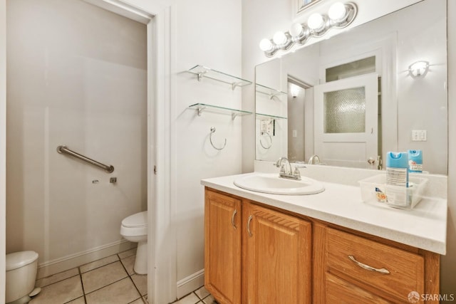 bathroom featuring toilet, tile patterned floors, vanity, and baseboards