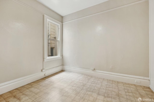 spare room featuring tile patterned floors and baseboards
