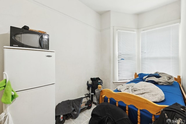 bedroom with freestanding refrigerator