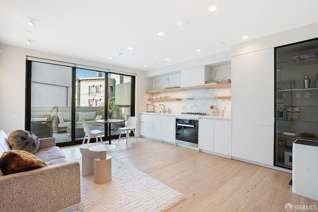 interior space featuring white cabinets, modern cabinets, oven, light countertops, and open shelves