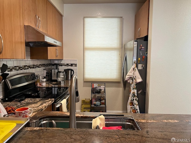 kitchen featuring stainless steel appliances, backsplash, and extractor fan