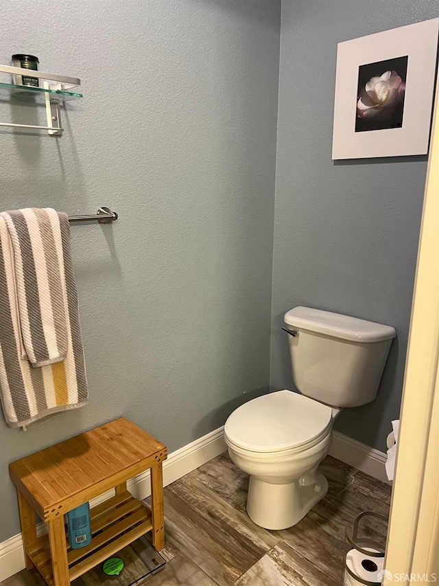 bathroom with hardwood / wood-style flooring and toilet