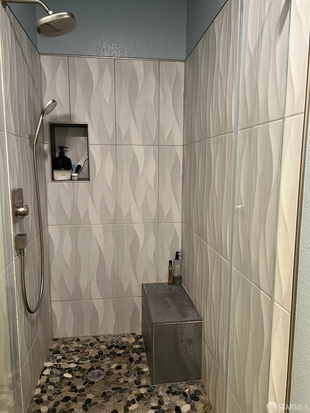 bathroom featuring a tile shower and tile walls