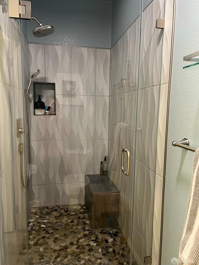 bathroom featuring tile walls and a shower with shower door