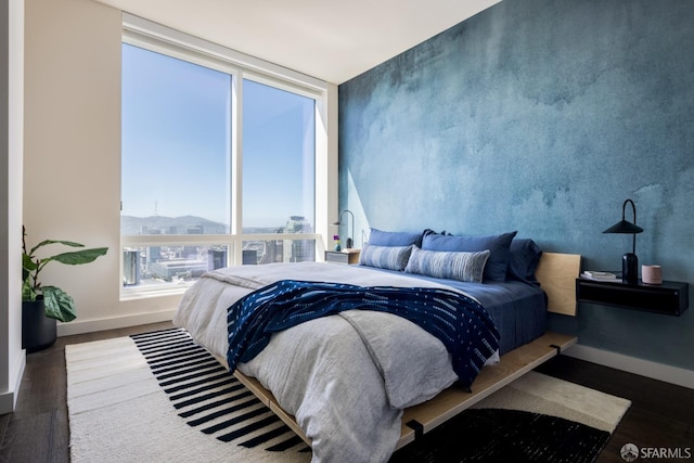 bedroom featuring floor to ceiling windows and dark hardwood / wood-style floors