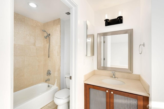 full bathroom featuring tile patterned flooring, vanity, tiled shower / bath combo, and toilet