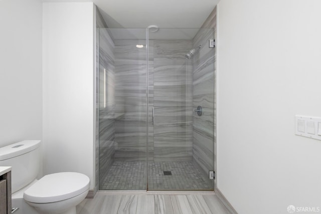 full bathroom with toilet, vanity, and a stall shower