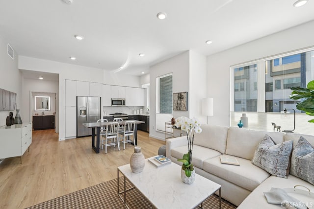 living area featuring visible vents, recessed lighting, and light wood-type flooring