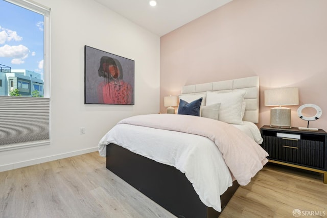 bedroom with baseboards, wood finished floors, and recessed lighting