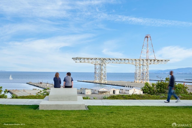 surrounding community with a lawn and a water view