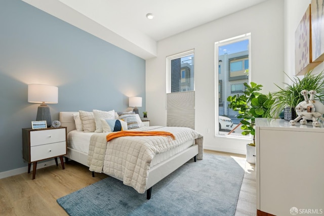 bedroom featuring baseboards and light wood finished floors