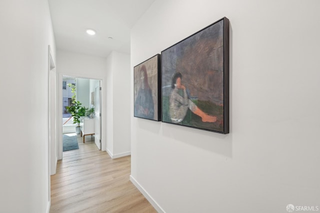 corridor with baseboards, light wood-style flooring, and recessed lighting